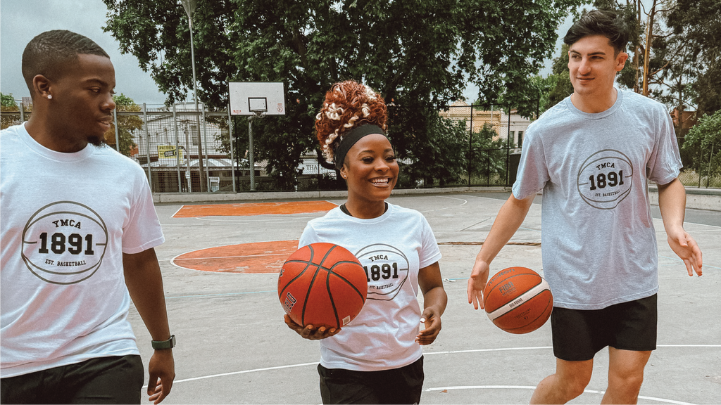 2 man and one woman, smiling and walking on a basketball court